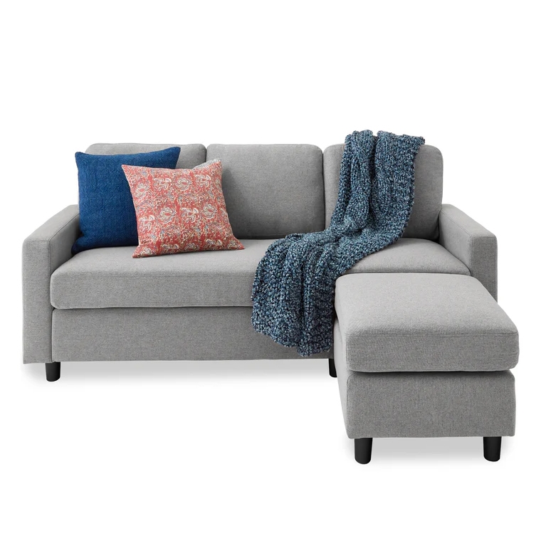 Gray sectional sofa with a right-side chaise, featuring a blue throw blanket and two decorative pillows—one blue and one with a red pattern.