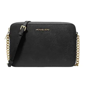 Black crossbody bag with gold chain and adjustable strap, featuring the \“Michael Kors\“ logo in gold.