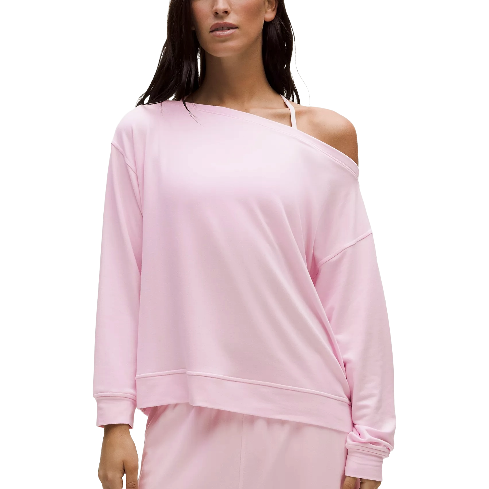 A person is wearing a light pink, off-shoulder, long-sleeve top with casual styling, paired with matching bottoms.