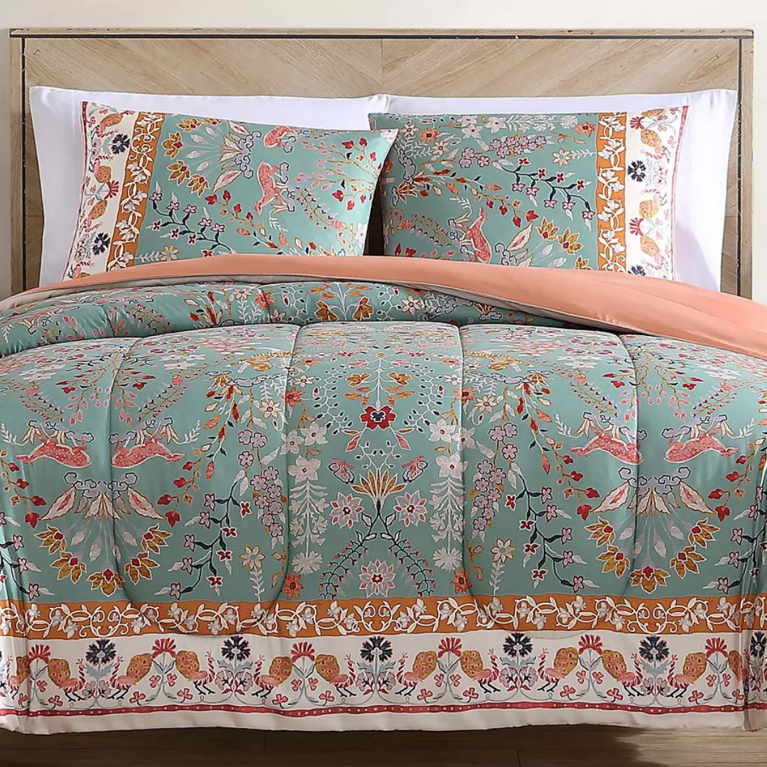 A floral-patterned bedding set featuring a quilt and two pillow shams in a mix of teal, coral, and earthy tones with intricate botanical and decorative motifs.