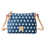 A polka dot crossbody bag with a blue background and white dots, featuring a Dooney & Bourke label and beige adjustable straps.