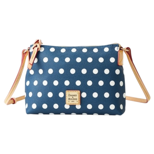 A polka dot crossbody bag with a blue background and white dots, featuring a Dooney & Bourke label and beige adjustable straps.