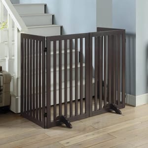 Free Standing Pet Gate with Support Feet is a dark-colored, folding gate with vertical slats, designed to block access to stairs or rooms. It includes wide base feet for stability and features hinges for flexible configuration.