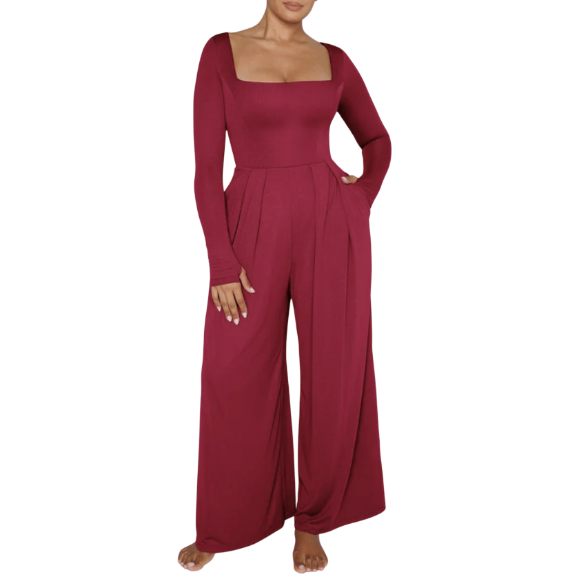 A burgundy long-sleeve jumpsuit with a square neckline, featuring wide-leg pants and pleated detailing at the waist, with pockets.