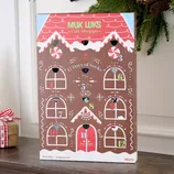 Gift box featuring a \“12 Days of Socks\“ theme from Muk Luks, designed like a gingerbread house with numbered doors, each containing a pair of socks for men's shoe sizes 8-12.