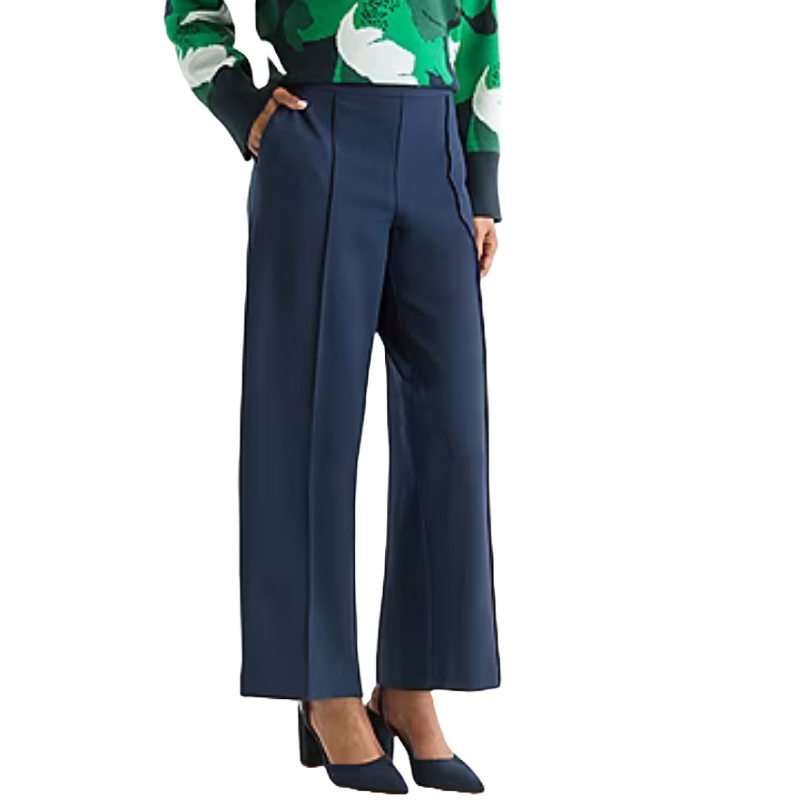 Wide-leg navy trousers paired with a green and white patterned sweater and navy heels.