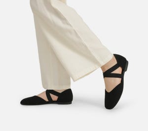 Black strappy flats paired with cream cropped trousers.