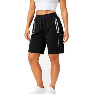 Woman wearing black athletic shorts with white trim and a white crop top, paired with white sneakers.