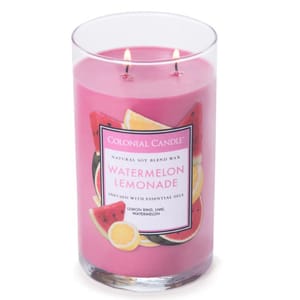 A pink Watermelon Lemonade candle by Colonial Candle, featuring a natural soy blend wax and infused with essential oils including lemon rind, lime, and watermelon. The glass jar has two wicks.