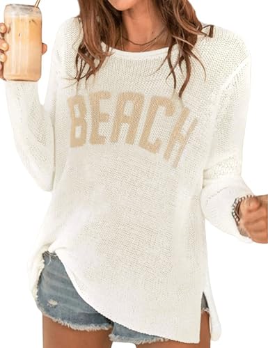Woman wearing a white knit sweater with \“BEACH\“ text and distressed denim shorts, holding a beverage.