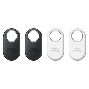 Four Samsung Galaxy SmartTag+ devices are displayed, two in black and two in white, each with a centered circular cutout for attaching to objects.