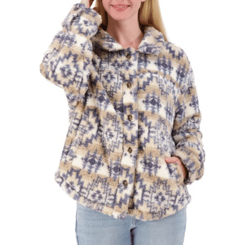A cozy, high-pile fleece shacket with a geometric pattern in beige, blue, and white, featuring a button-up front and a relaxed fit, worn with light blue jeans.
