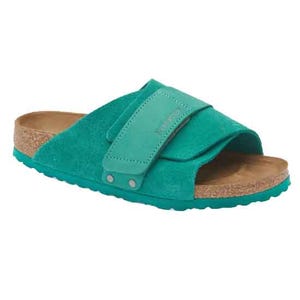 Turquoise suede sandal with a cork footbed and a wide adjustable strap, featuring a rugged turquoise sole.