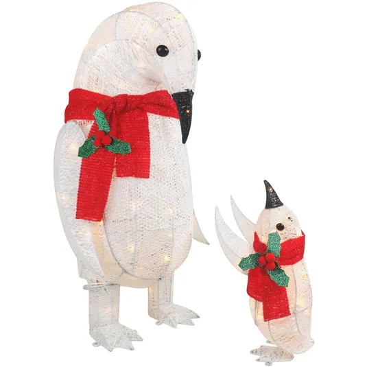 Two illuminated penguin decorations, featuring a large penguin and a smaller one, each adorned with red scarves and holly.
