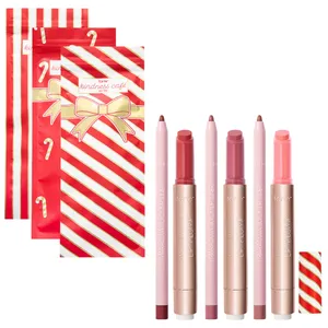Three lip liner and Maracuja Juicy Lip Plump sets from Tarte, featuring shades of pink and red, are accompanied by festive red and white striped packaging adorned with candy cane motifs.