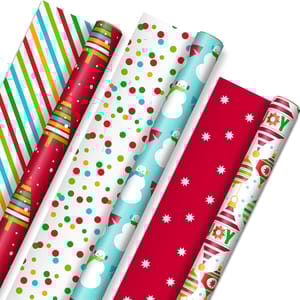 A pack of Hallmark reversible gift wrap featuring festive designs: colorful stripes, Christmas trees, polka dots, snowmen, stars, and holiday-themed patterns. Each roll offers different holiday motifs for versatile wrapping options.