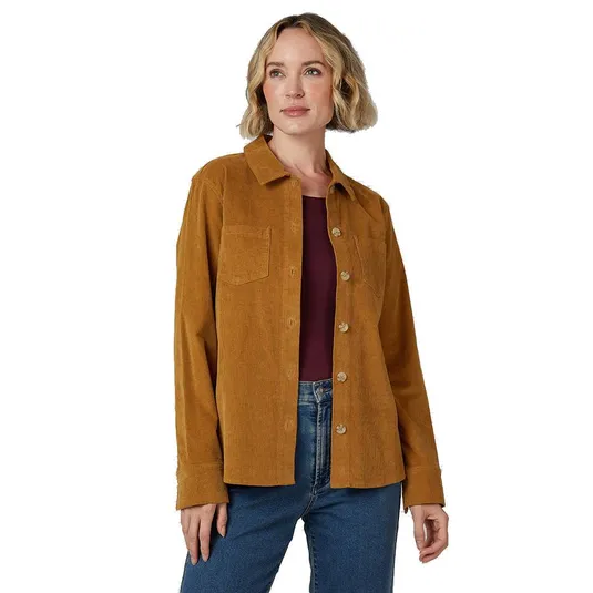 A woman wears a light brown corduroy button-up shirt with a single chest pocket over a maroon top and blue jeans.