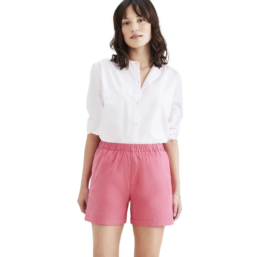 A woman is wearing a white button-up shirt with rolled sleeves and pink elastic-waist shorts.