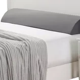 Nestl Memory Foam Wedge Pillow with a gray cover is designed for added support and comfort, featuring a sloped shape. It is placed on a white bed with a gray blanket.
