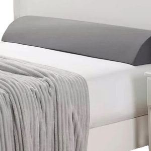 Nestl Memory Foam Wedge Pillow with a gray cover is designed for added support and comfort, featuring a sloped shape. It is placed on a white bed with a gray blanket.