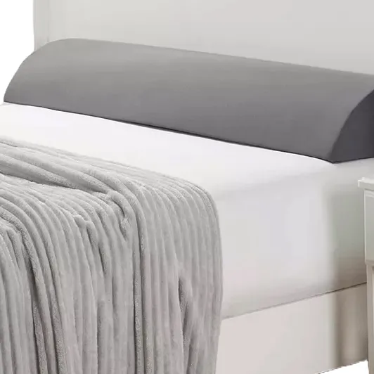 Nestl Memory Foam Wedge Pillow with a gray cover is designed for added support and comfort, featuring a sloped shape. It is placed on a white bed with a gray blanket.
