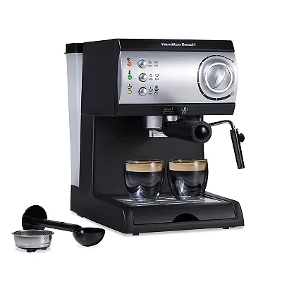 A Hamilton Beach espresso and cappuccino maker with a stainless steel finish and black accents, featuring multiple control buttons, a steam wand, and two cups of espresso.