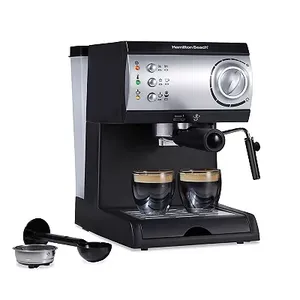 A Hamilton Beach espresso and cappuccino maker with a stainless steel finish and black accents, featuring multiple control buttons, a steam wand, and two cups of espresso.