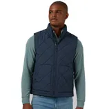 A man wearing a blue, diamond-quilted vest from 32 Degrees. The vest features a full front zipper and two side pockets, layered over a long-sleeve, light green shirt with blue jeans.