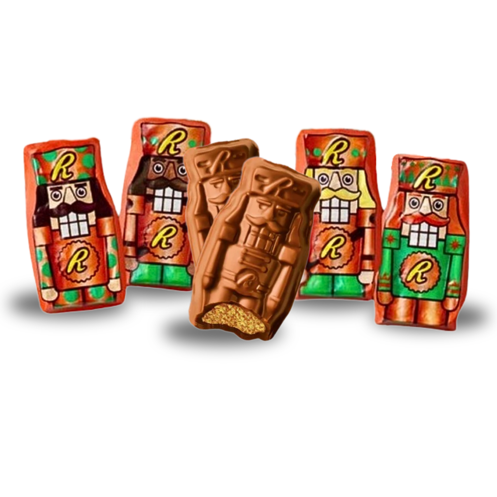 Five chocolate bars shaped and wrapped as nutcrackers with colorful foil packaging featuring an \“R\“ logo. Two bars are unwrapped, one with a bite taken, showing a creamy, textured filling.