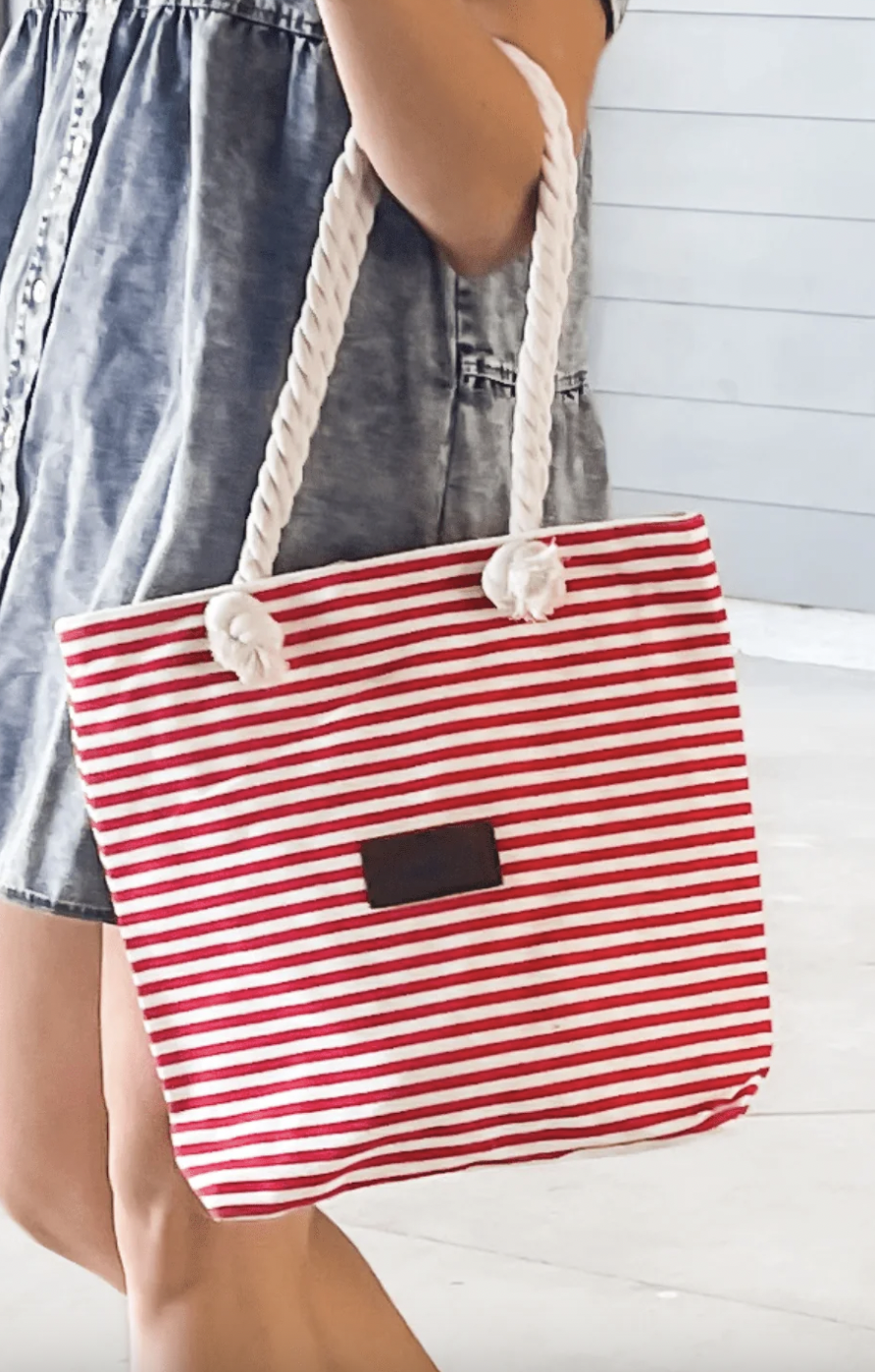 Red and white striped canvas tote bag with rope handles and a small rectangular patch on the front.