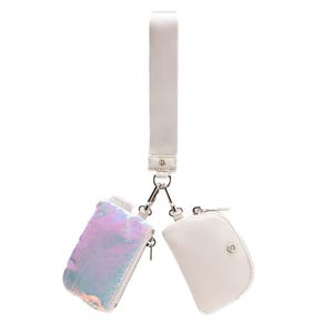 A dual pouch wristlet features an iridescent pouch and a white pouch connected by a detachable white strap, each with a zipper closure and metal clasps.