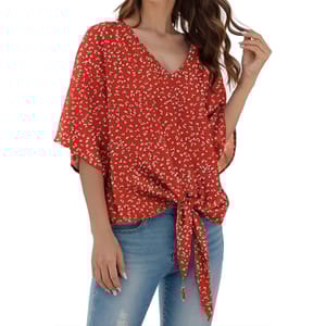 A red, floral-patterned blouse with short sleeves features a V-neckline and a front tie detail, paired with light blue denim jeans.