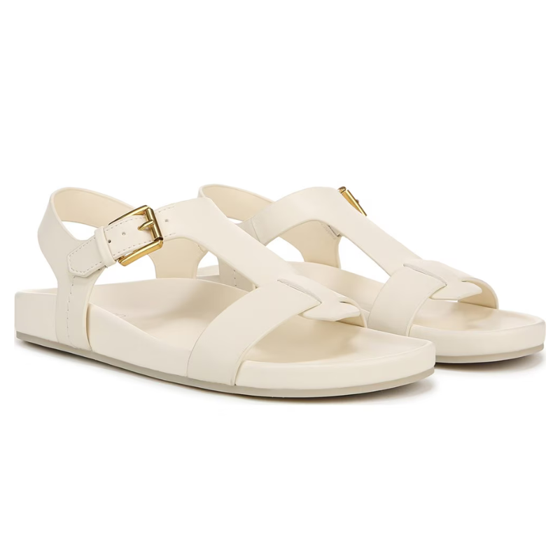 Cream-colored sandals featuring a T-strap design with buckles and flat soles.
