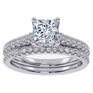 A bridal set featuring a princess-cut diamond at the center with two bands adorned with smaller round diamonds. The design showcases a total weight of 1/2 carat, mounted on a silver-colored metal, likely white gold or platinum.
