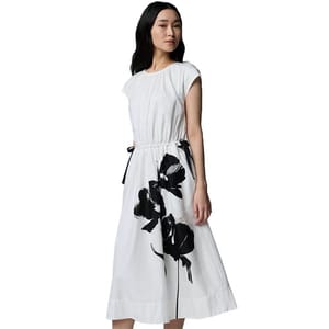 White midi dress with black floral print, cap sleeves, and a gathered waist with side tie detail.