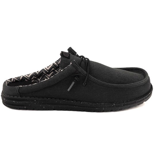 Black slip-on shoe with a speckled sole and a patterned inner lining, featuring lace-up detailing for added style.
