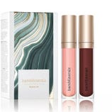 bareMinerals Clean On set with two lip glosses in light pink and burgundy shades, accompanied by a decorative box featuring a swirling green and white design.