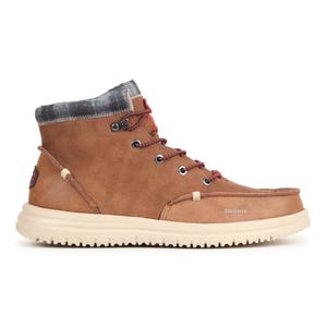 Hey Dude Bradley Classic Shoes are mid-height, tan casual shoes with a textured sole, plaid fabric at the ankle, metal eyelets, and red-accented laces. They offer a blend of comfort and style.
