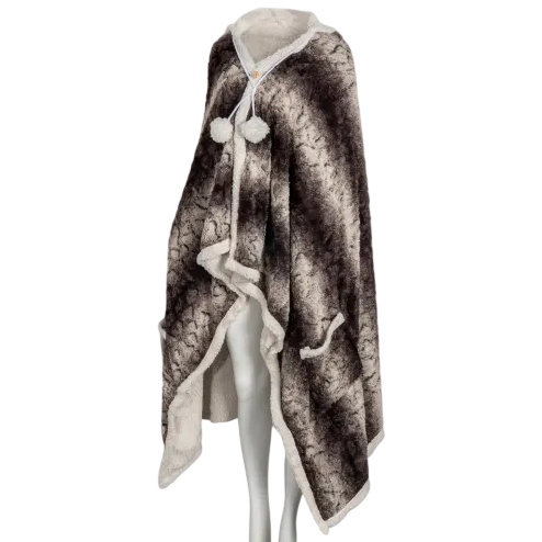 A cozy hooded faux fur cape with a soft, dark patterned exterior and white inner lining, featuring a button closure with pom-pom details.