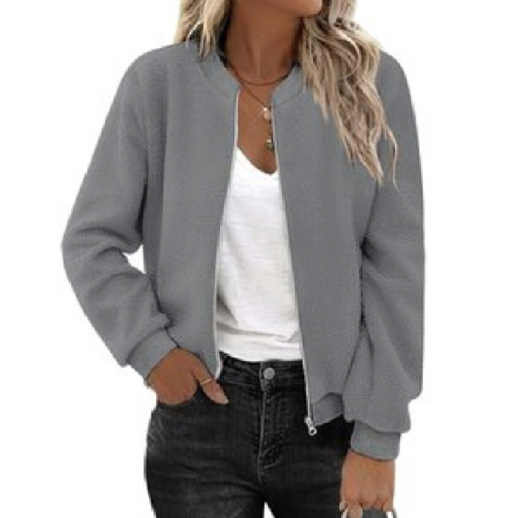 A gray bomber jacket is paired with a white T-shirt and dark jeans, accessorized with layered necklaces.