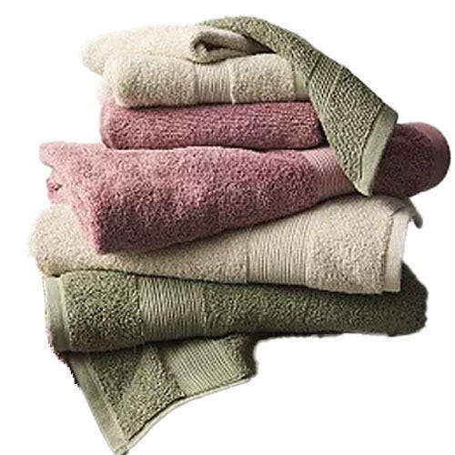 A stack of assorted colored bath towels, including cream, pink, and green, neatly folded.