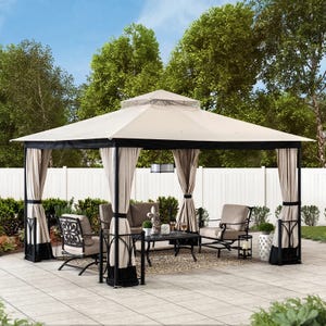 A beige outdoor gazebo with curtains, accompanied by a patio furniture set consisting of chairs, a sofa, and a coffee table.