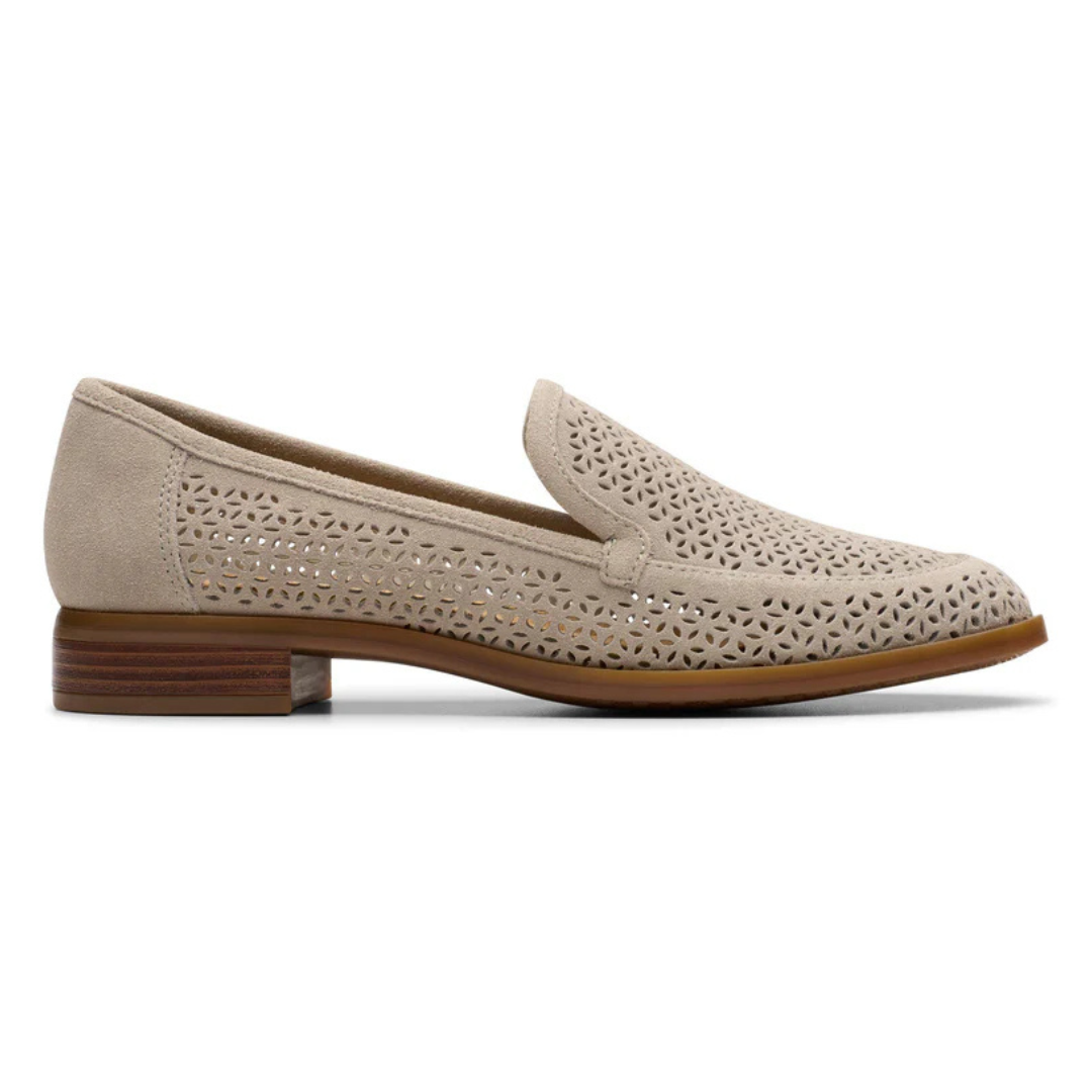 Beige perforated loafer with a stacked low heel and decorative cut-out design.