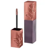 A cosmetics item featuring a glossy, rose gold and dark purple square-shaped container with an embossed \“UD\“ logo, containing a doe-foot applicator likely for lip gloss or liquid lipstick.