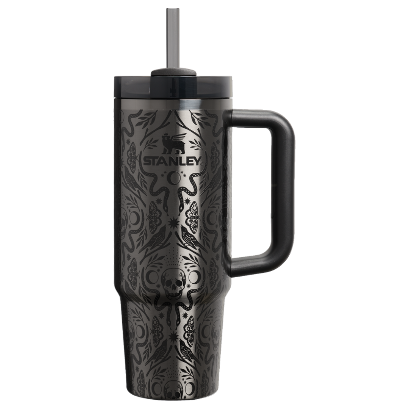 Stanley tumbler with a handle, featuring a black design with skulls, snakes, and floral patterns.