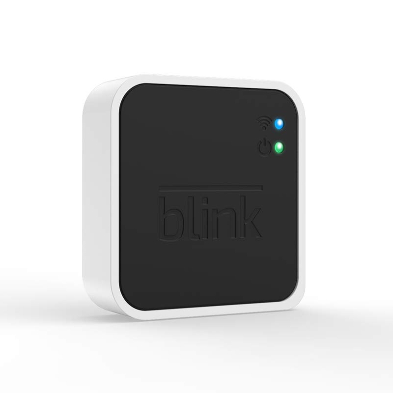 The Blink Add-On Sync Module 2 is a compact device with a black front featuring \“blink\“ branding and two indicator lights for power and connectivity. It serves as a hub for Blink security cameras, managing their operations and storage interactions.