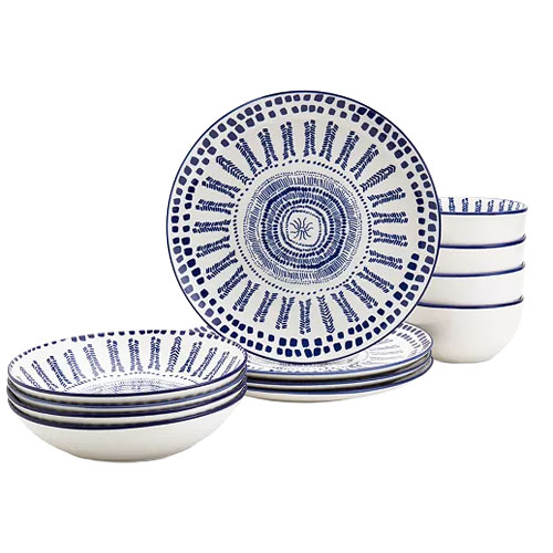 A set of blue and white patterned ceramic dinnerware, including four plates, four bowls, and four mugs. The design features intricate circular and linear patterns.
