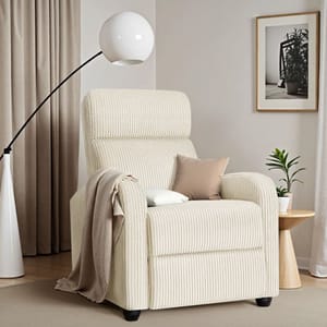 Cream-colored corduroy massage recliner with a high back, accompanied by a beige throw and a pillow, set next to a round side table and a modern floor lamp, in a neutral-toned room.