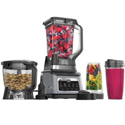 A multi-component kitchen system includes a blender with a pitcher full of berries, a food processor with dough, and a personal blender cup with a pink smoothie and another with mixed fruits and vegetables.