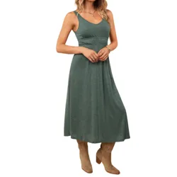 Woman wearing a teal sleeveless midi dress with a V-neckline, paired with tan heeled cowboy boots.